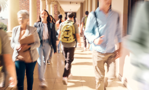 Students walking along a campus pathway, suggesting the transition from college learning to professional practice.