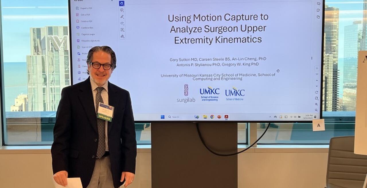 Image of Dr Sutkin next to his presentation