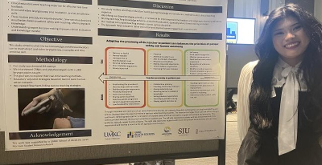Alleana standing next to poster