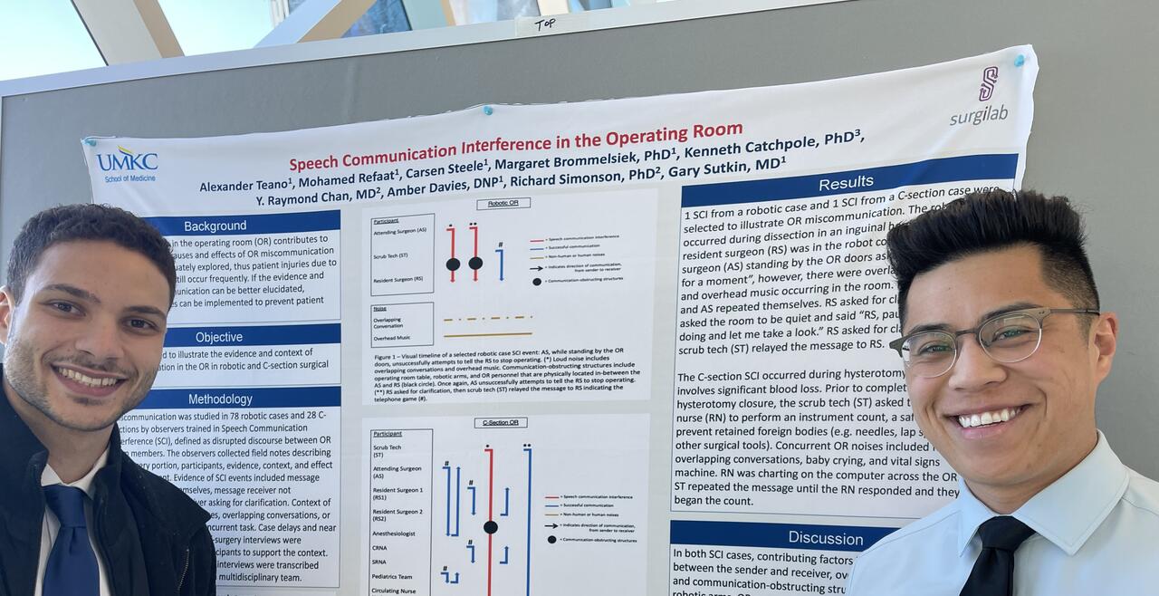 Image of Alex and Mohamed next to their poster