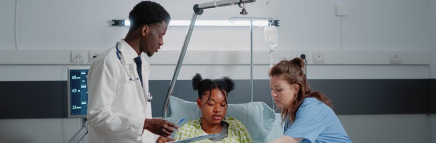 Patient in hospital bed with medical staff