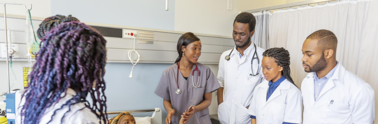 pateint in bed surrounded by medical students